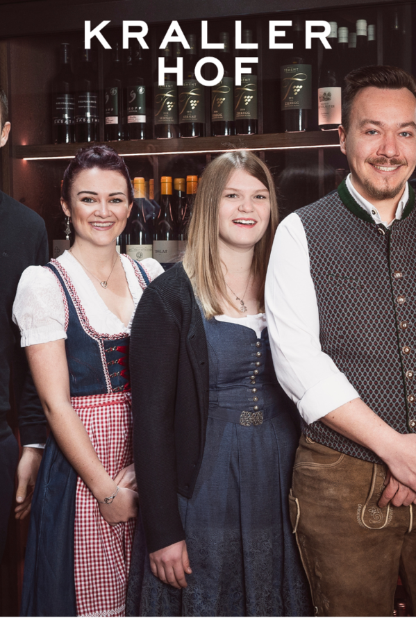 Vier Personen vor Weinregal mit Schriftzug Krallerhof