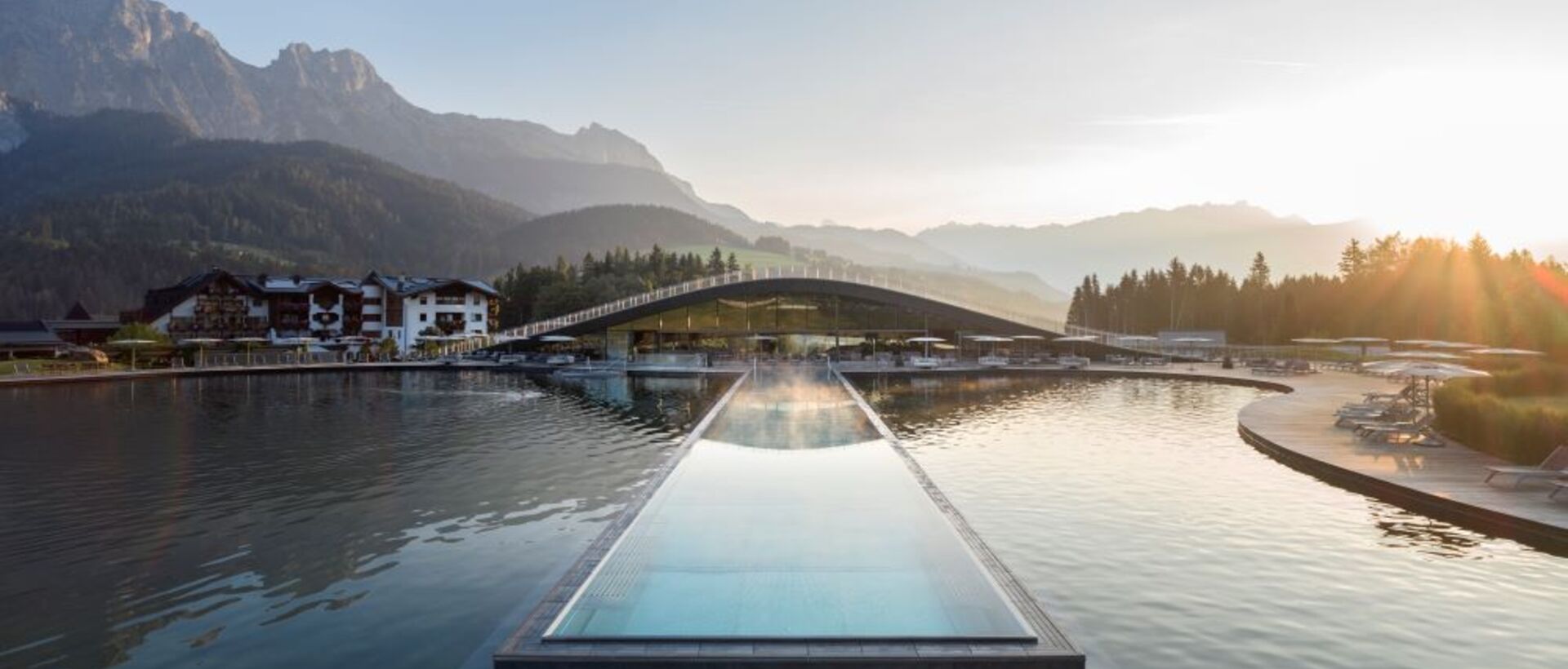Infinity-Pool im Krallerhof mit Blick auf Berglandschaft und See im Sommer
