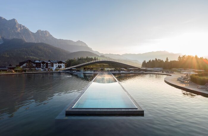 Infinity-Pool im Krallerhof mit Blick auf Berglandschaft und See im Sommer