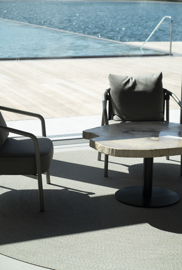 Minimalistischer Sitzbereich am Infinity-Pool mit modernem Design und Blick aufs Wasser
