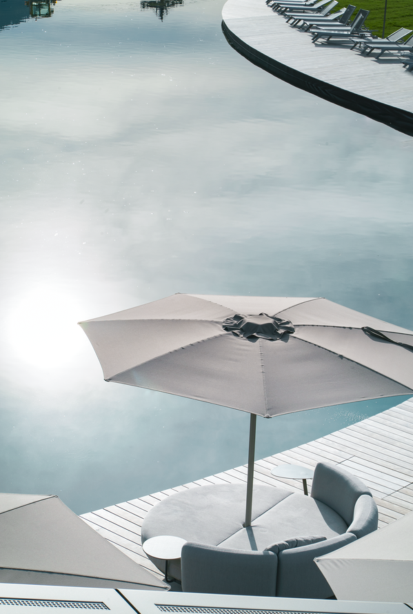 Weißer Sonnenschirm auf Holzterrasse an einem sonnigen Tag