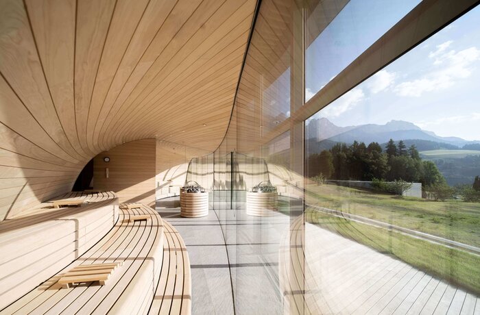 Sauna mit Holzliegen und Blick auf grüne Landschaft durch Fenster