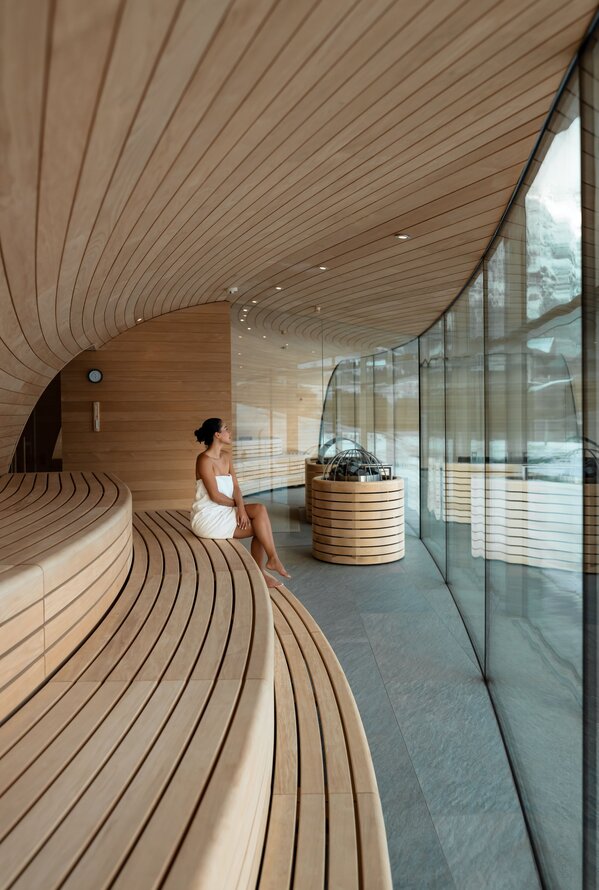 Stilvoller Wellnessbereich mit geschwungenem Holzdesign und entspannter Atmosphäre.