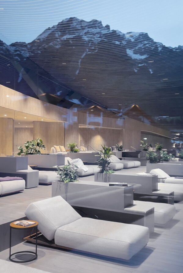 Relaxation area with white loungers in front of a mountain panorama in the blue hour