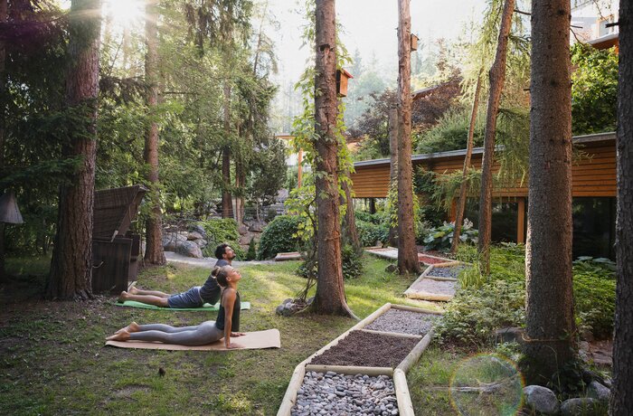 Mann und Frau machen Yoga im Garten