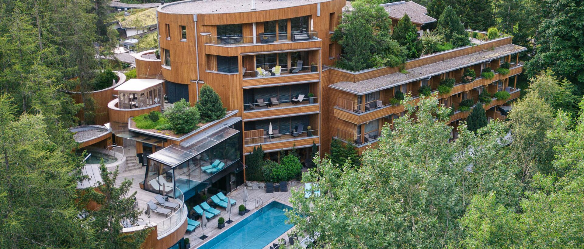 Hotelanlage mit Pool in grüner Berglandschaft