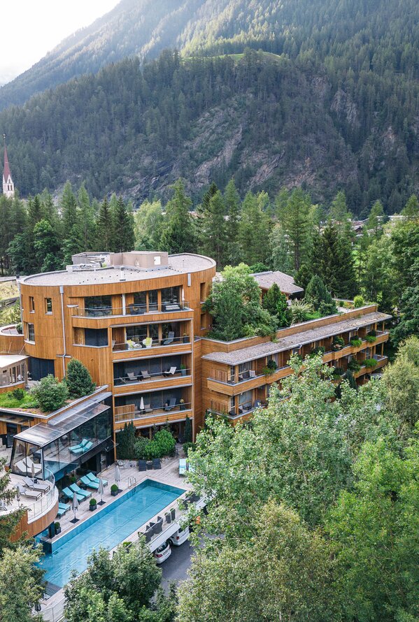 Naturhotel Waldklause mit Pool in grüner Berglandschaft