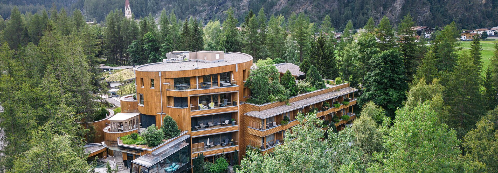 Naturhotel Waldklause mit Pool in grüner Berglandschaft