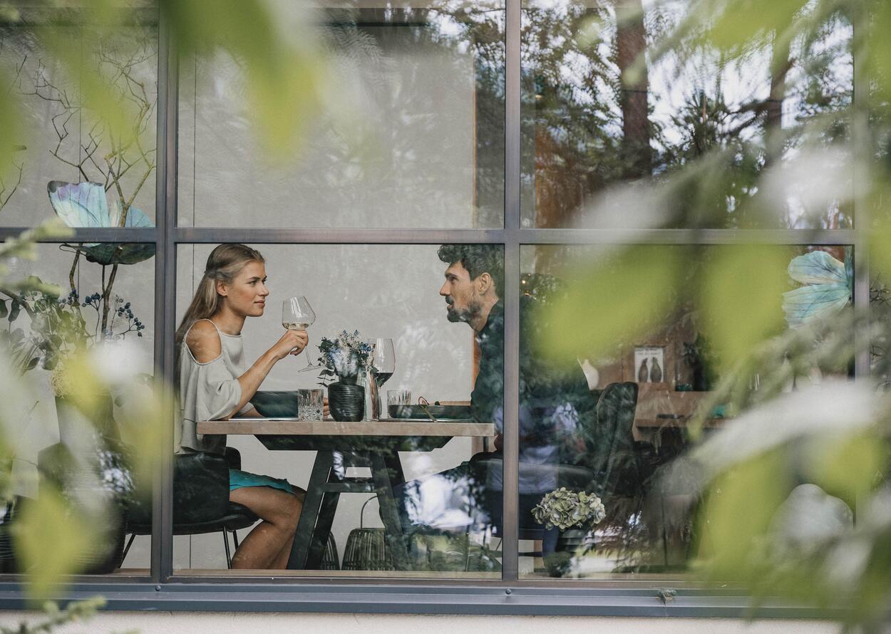 Ein Mann und eine Frau sitzen in einem Restaurant und trinken gemeinsam Wein.