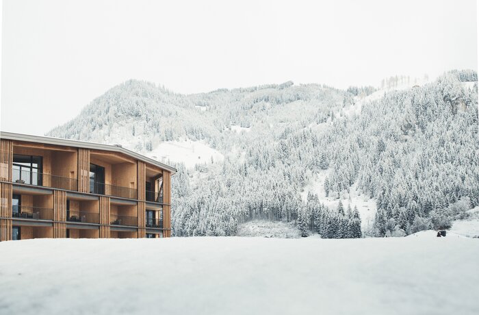 Hotel vor verschneitem Berg und schneebedeckter Landschaft