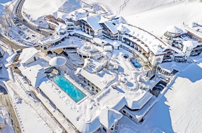 Hotelanlage mit Pools und verschneiten Dächern aus der Vogelperspektive