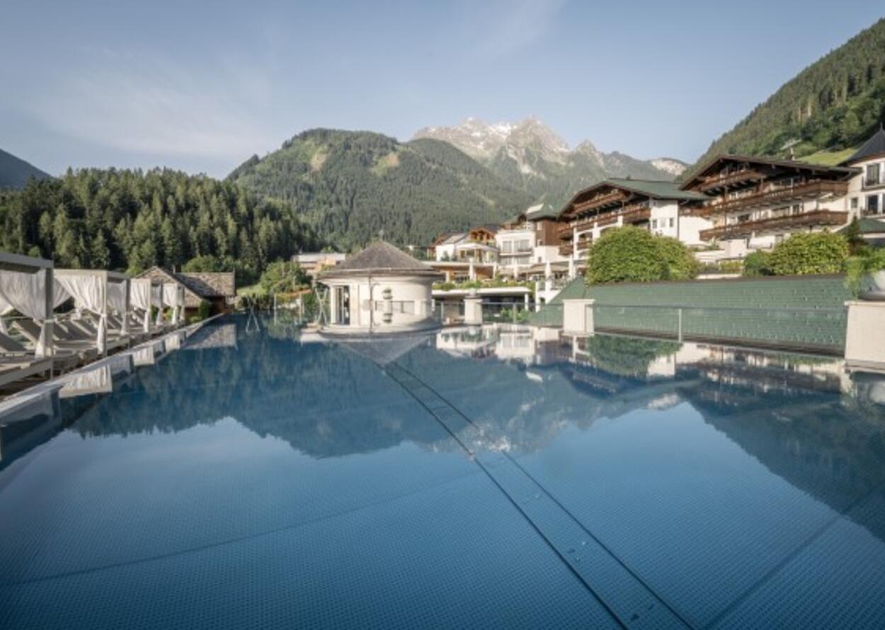 Pool mit Spiegelung von Gebäuden und Bergen im Hintergrund