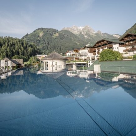 Pool mit Spiegelung von Gebäuden und Bergen im Hintergrund