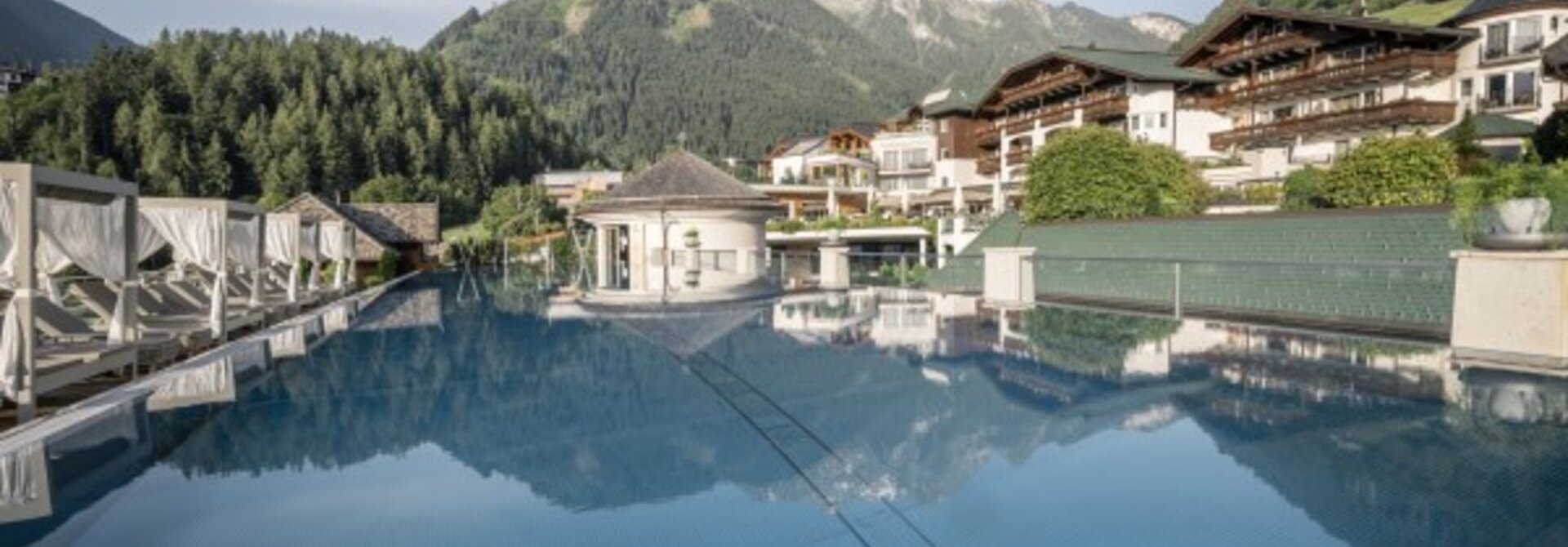 Pool mit Spiegelung von Gebäuden und Bergen im Hintergrund