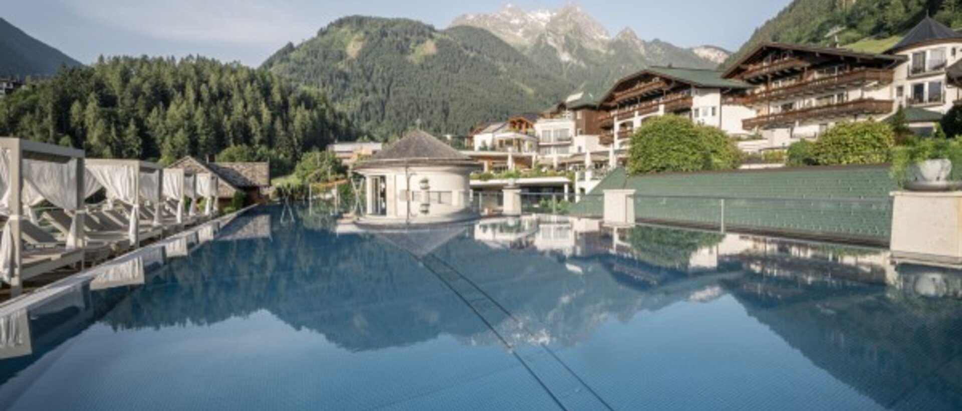 Pool mit Spiegelung von Gebäuden und Bergen im Hintergrund