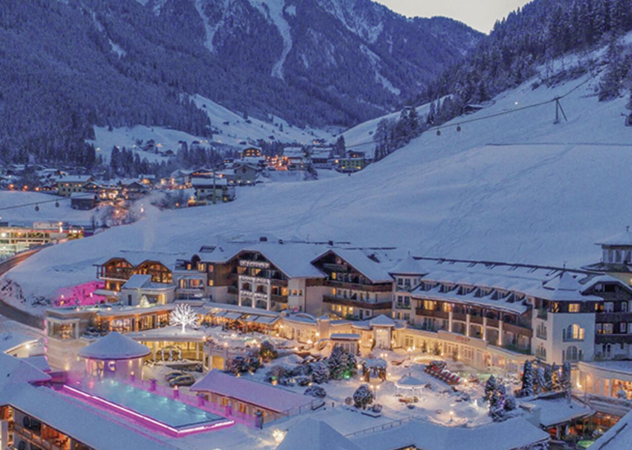 Hotel complex in winter resort with snow-capped mountains in the background