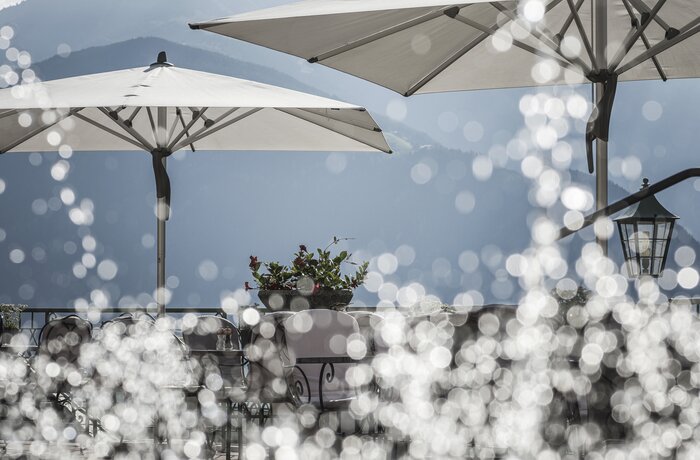 Terrasse im Stock Resort mit Sonnenschirmen und Blick auf die Tiroler Bergwelt