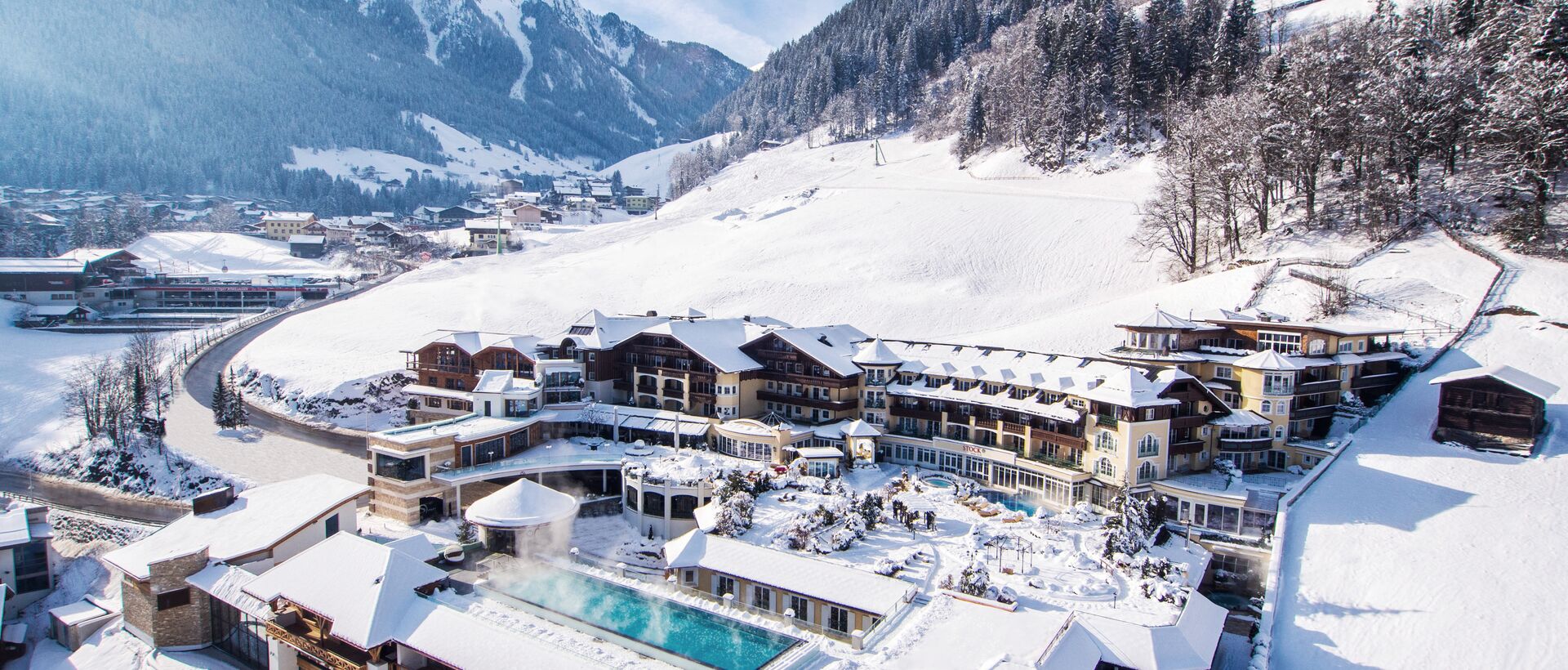 Schneebedecktes Alpenresort leuchtet warm in einer wunderschönen Winter-Berglandschaft.