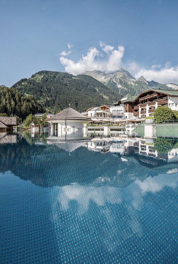 STOCK Resort mit Pool, Bergen und Gebäuden im Hintergrund unter blauem Himmel