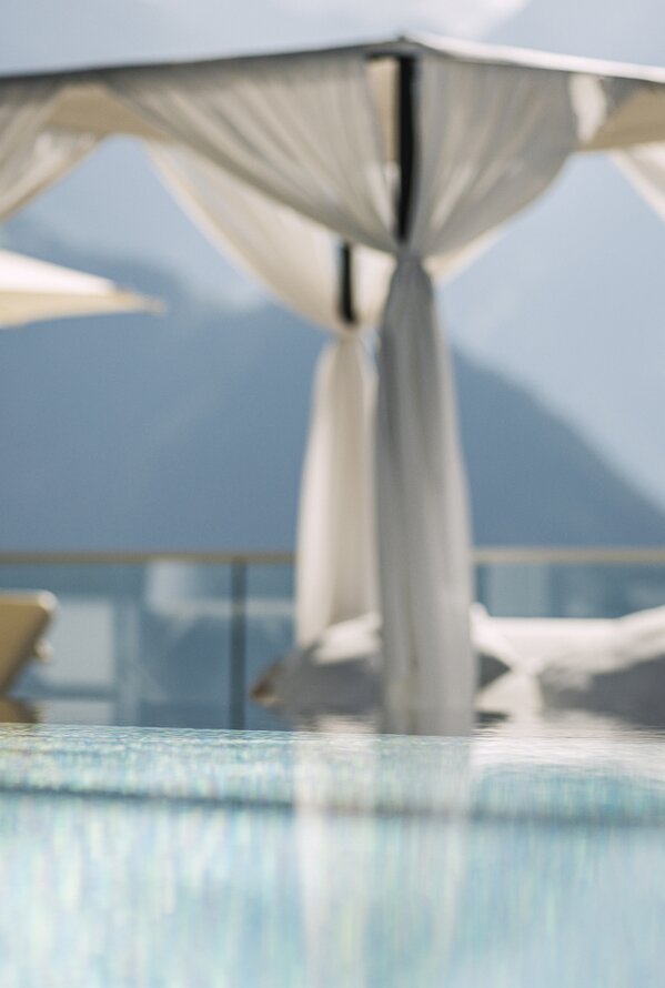 Ruhebereich am Außenpool des Stock Resort mit Daybed und Bergblick