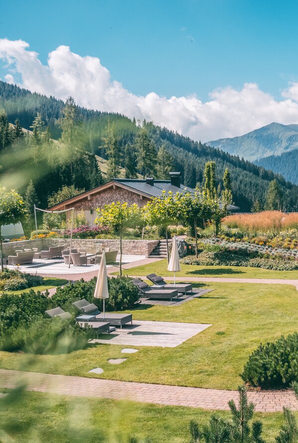 Peaceful garden area with loungers and mountain views.
