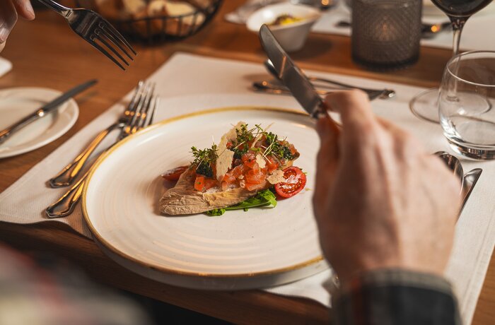 Finely plated appetizer on a restaurant table with cutlery and elegant dining atmosphere