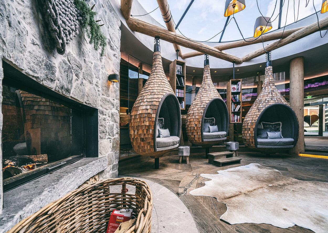 Hotel lounge with hanging baskets, fireplace and bookshelves