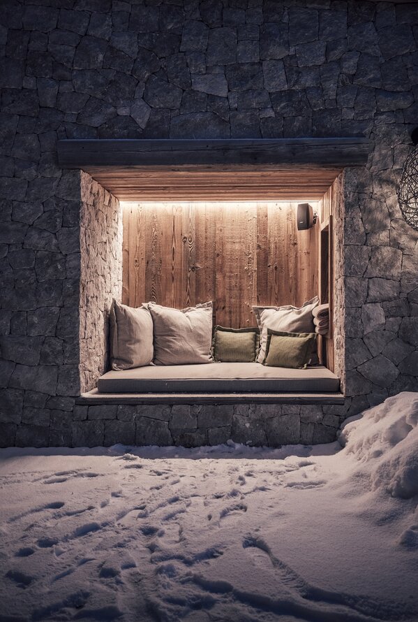 Brick niche with cushions and wood paneling in the snow