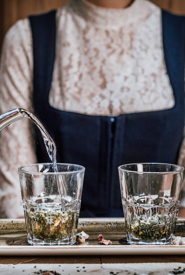Woman pouring tea into two glasses on a tray