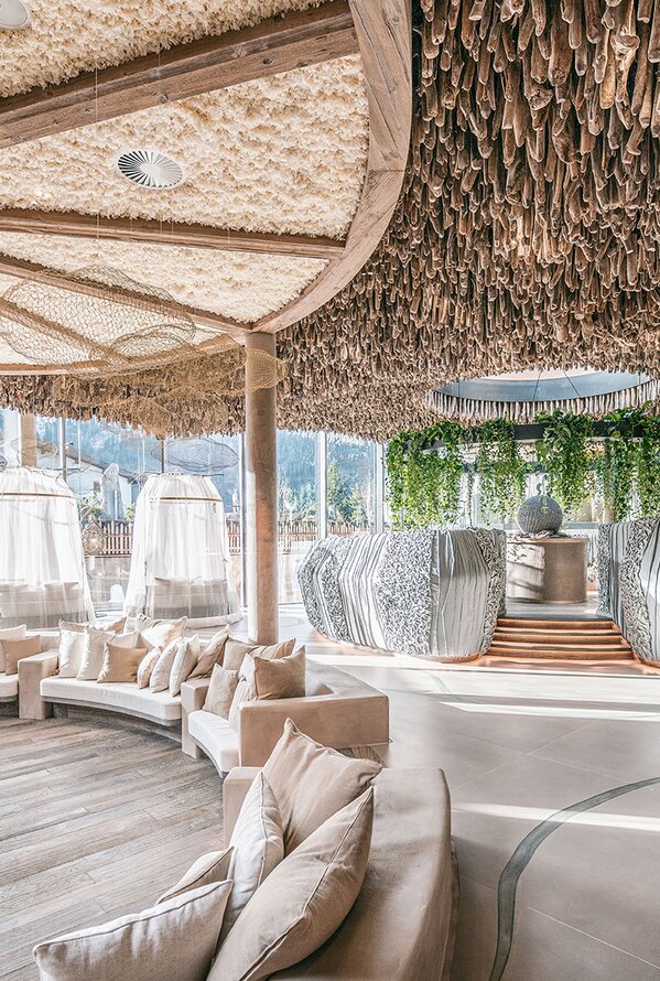 Interior view of a spa area with light wood, plants and seating