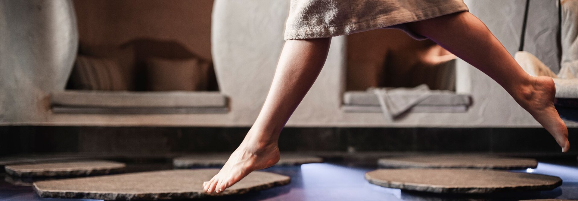 Barfuß durch den Wellnessbereich – natürliche Materialien und sanfte Sinneserlebnisse sorgen für pure Entspannung.