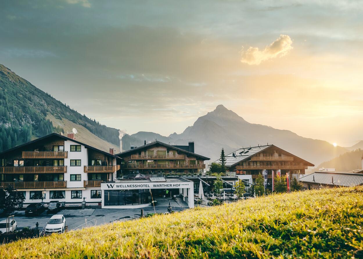 Wellness hotel Warther Hof in front of a mountain backdrop in the evening light