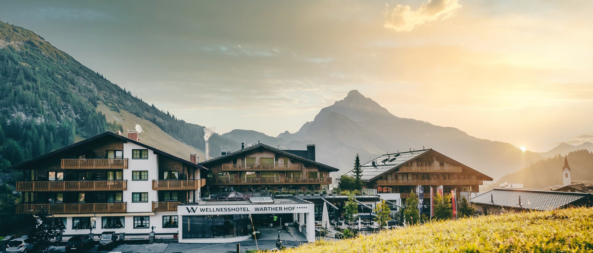 Wellness hotel Warther Hof in front of a mountain backdrop in the evening light