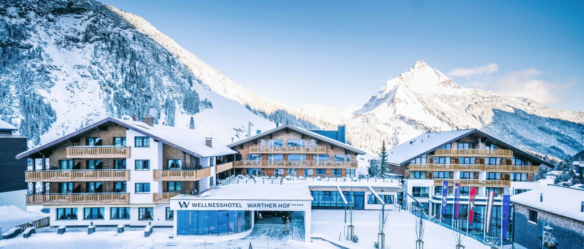 Hotel im Schnee vor Bergkulisse