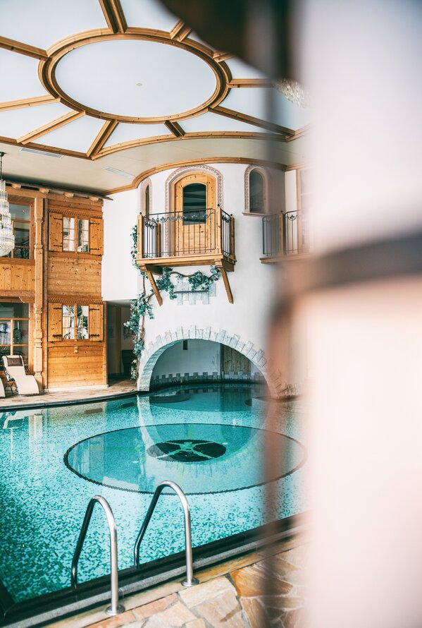 Elegant indoor pool with alpine charm and a peaceful wellness atmosphere.