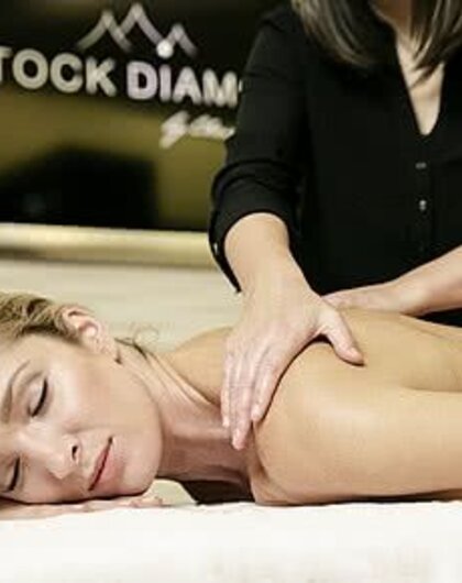 Frau liegt auf dem Bauch und wird massiert