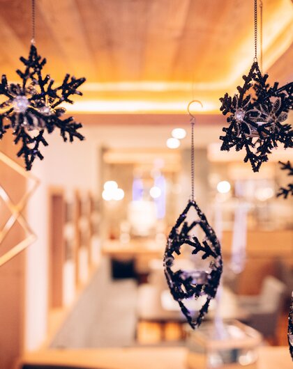 Dekorative, hängende Schneeflocken und Ornamente vor verschwommenem Hintergrund