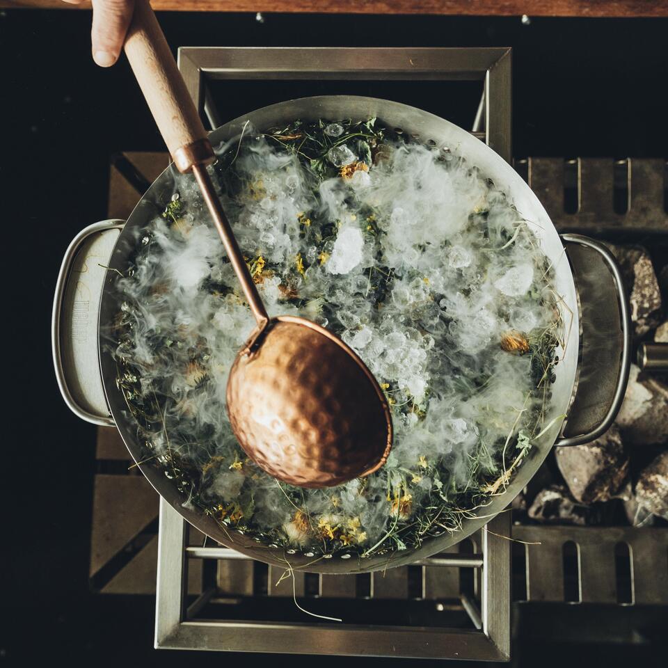 Large pot with ice, herbs and a ladle from above