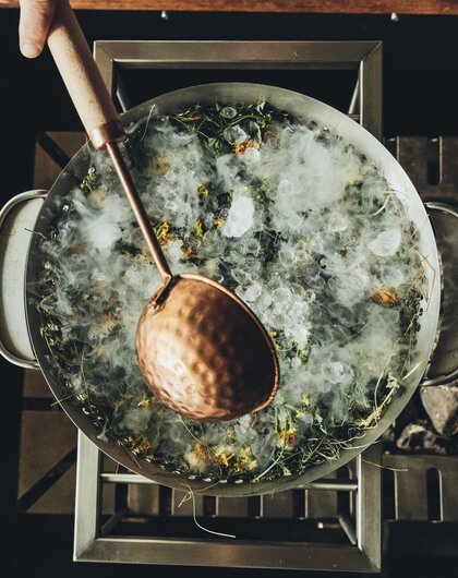 Large pot with ice, herbs and a ladle from above