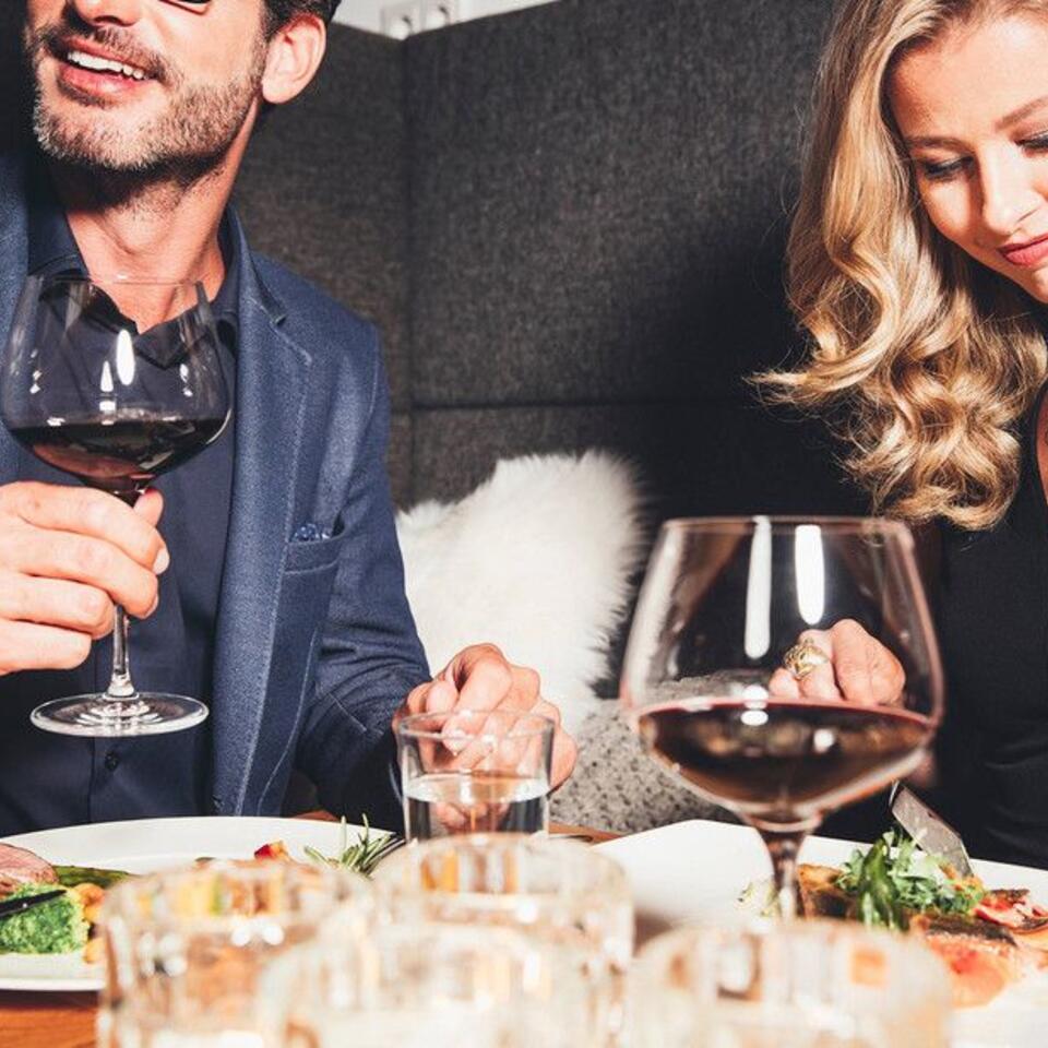 Paar beim Abendessen mit Wein und Speisen im Restaurant