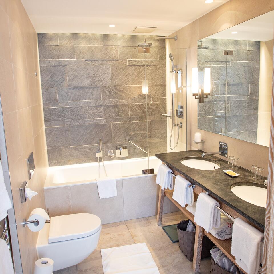 Modernes Badezimmer mit Badewanne, Dusche, zwei Waschbecken und Toilette