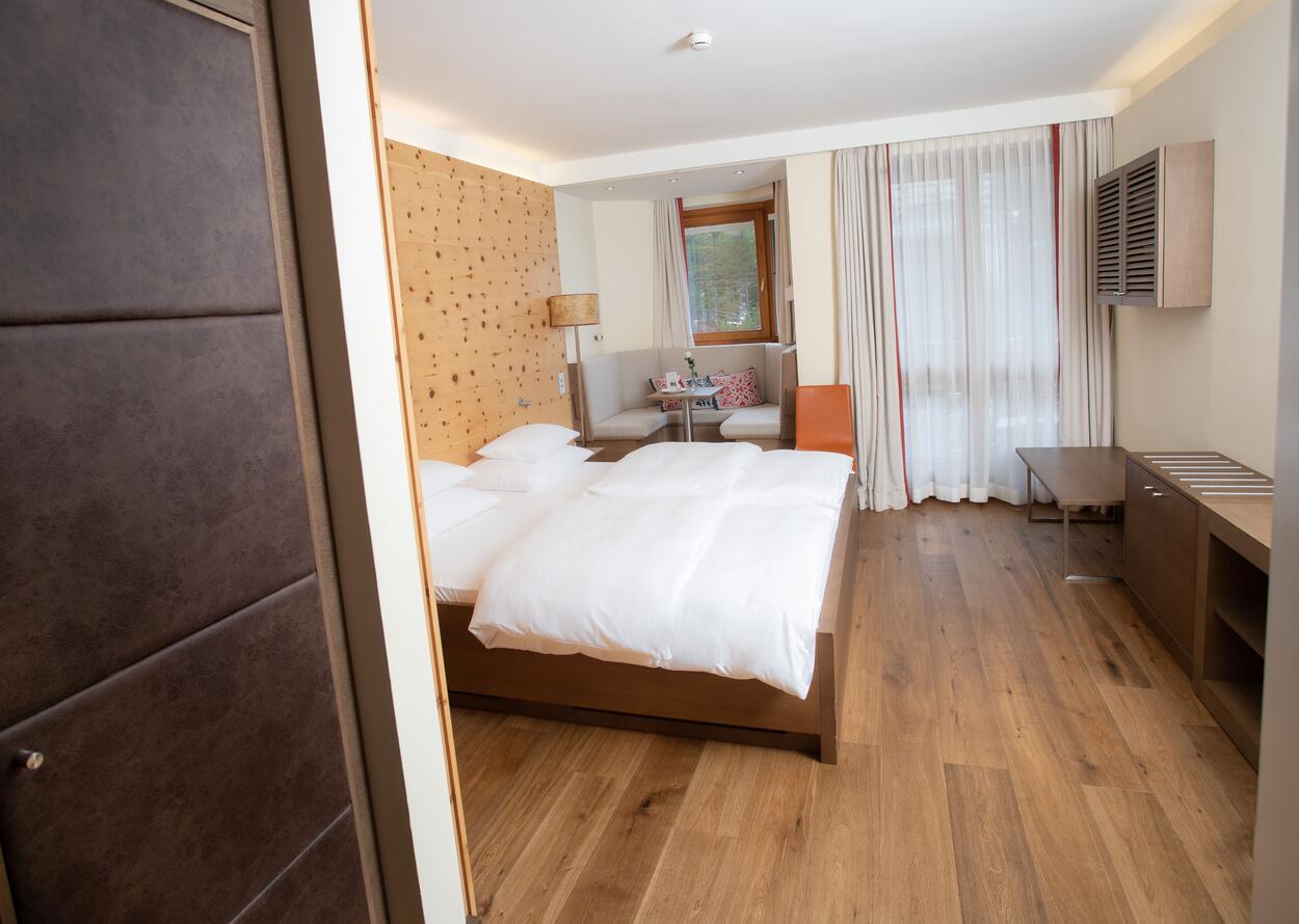 Bright hotel room with double bed, seating area and window