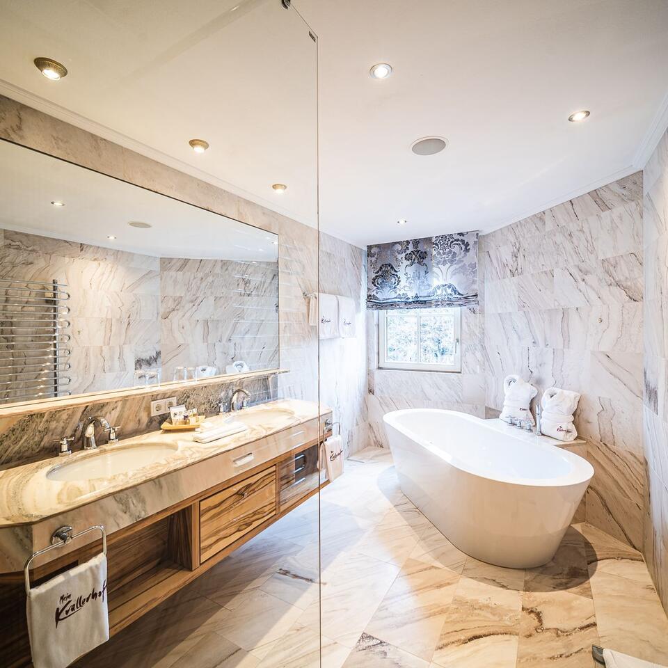 Modern bathroom with marble, bathtub and large mirror