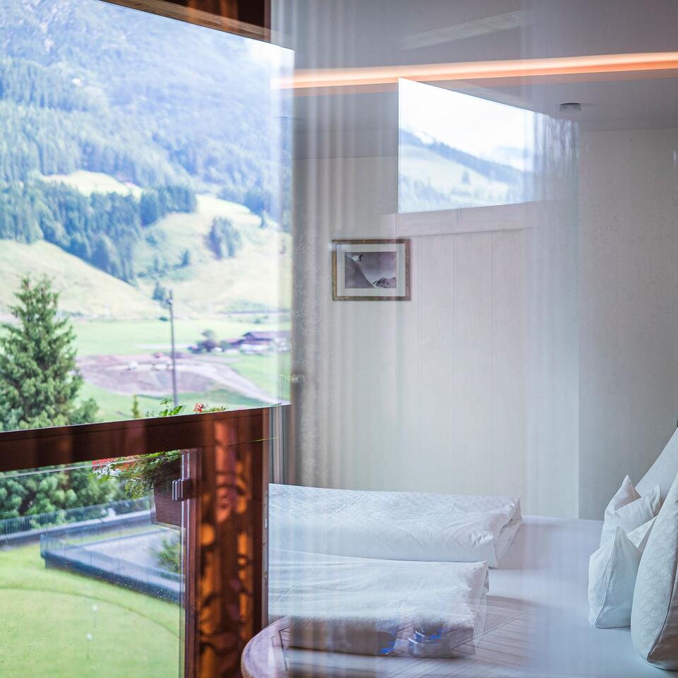 Bright room with bed and view of green hills