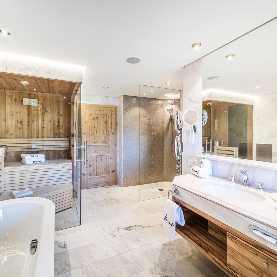 Helles Badezimmer mit Sauna, Dusche, Waschbecken und Spiegel