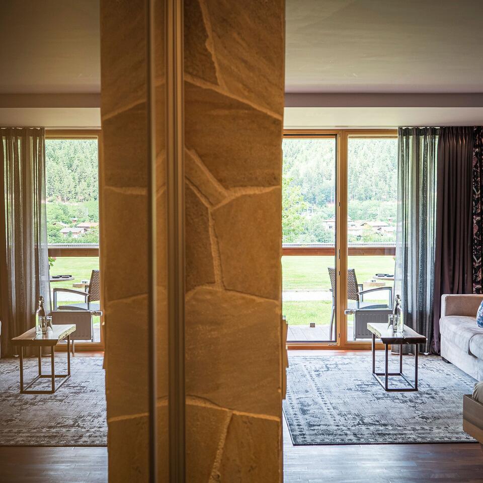 Hotel room with balcony view through stone wall