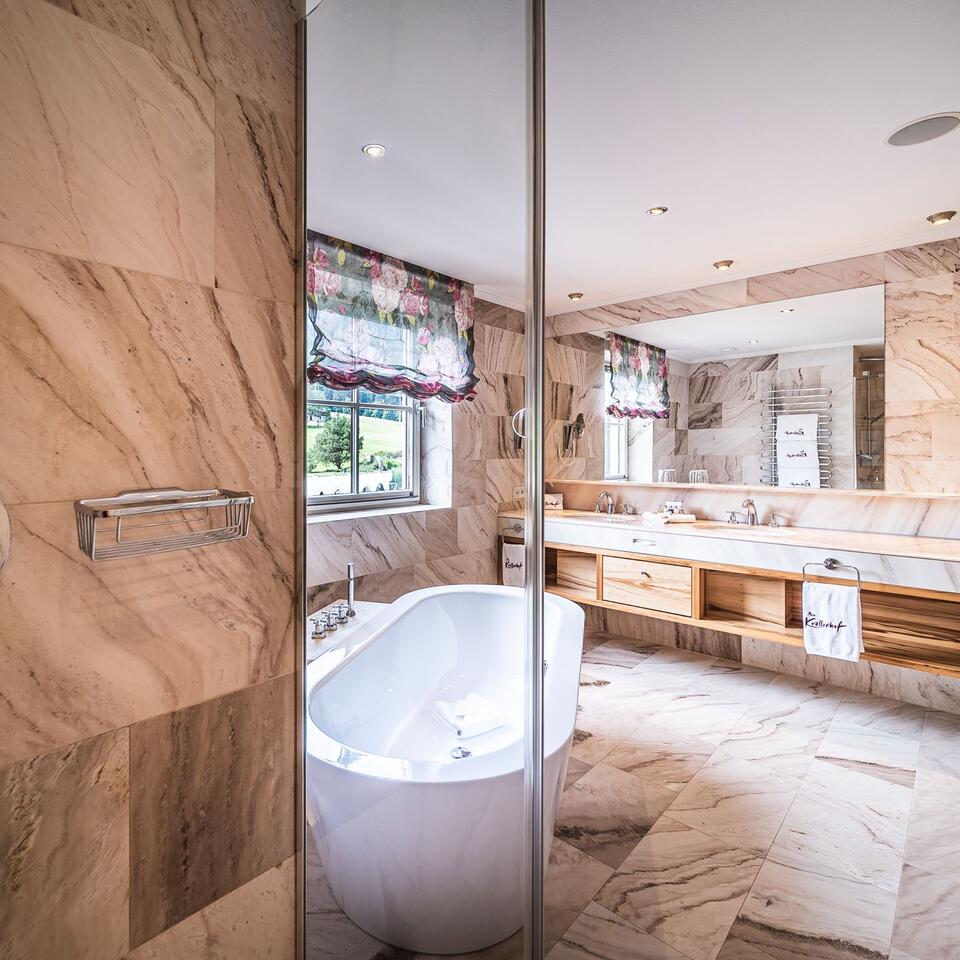 Modern bathroom with freestanding bathtub and marble tiles