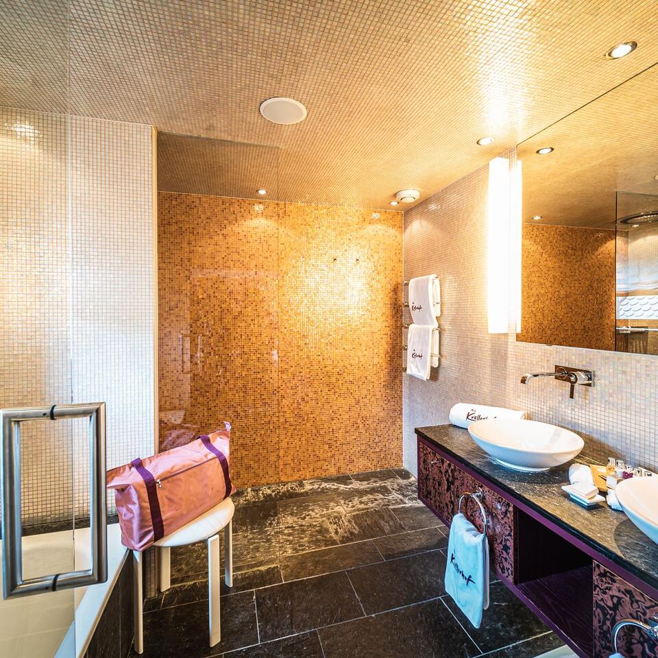 Modern bathroom with shower, sink and towels
