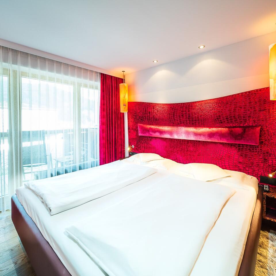 Hotel room with double bed and red wall