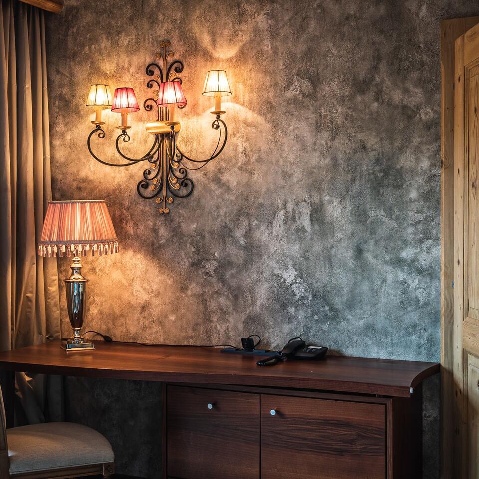 Wand mit Lampe und Tisch mit Lampe in einem Zimmer
